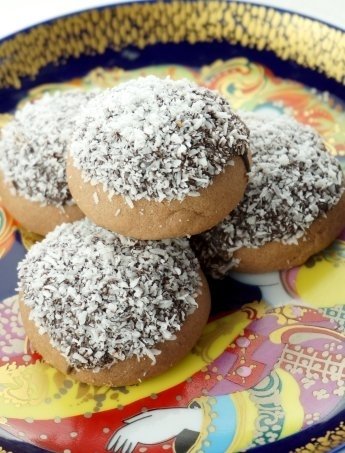Süßes Mürbeteiggebäck mit Kakao, Schokoladensoße und Kokosraspeln Süßes Mürbeteiggebäck mit Kakao, Schokoladensoße und Kokosraspeln